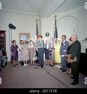 Visita dei volontari del corpo della Pace anziano, 12:30. Il presidente John F. Kennedy (ai microfoni) commenta durante una visita di volontari del corpo della Pace anziano, tra i 60 e i 76 anni, nella Sala dei Pesce della Casa Bianca, Washington, D.C. i volontari presenti includono: Beulah Bartlett; Gertrude Becker; Ralph Cole; Frances R. Cunha; William Darracott; Blythe Monroe; Melissa Moore; Cora Parrish; Alfred Pond; Lina Walden; Barbara Wiggins; Chester Wiggins. Foto Stock