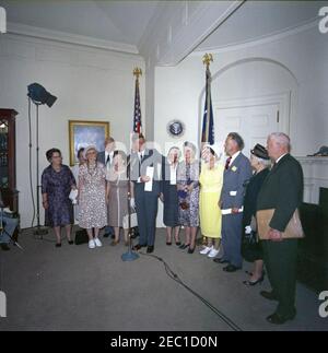 Visita dei volontari del corpo della Pace anziano, 12:30. Il presidente John F. Kennedy (ai microfoni) commenta durante una visita di volontari del corpo della Pace anziano, tra i 60 e i 76 anni, nella Sala dei Pesce della Casa Bianca, Washington, D.C. i volontari presenti includono: Beulah Bartlett; Gertrude Becker; Ralph Cole; Frances R. Cunha; William Darracott; Blythe Monroe; Melissa Moore; Cora Parrish; Alfred Pond; Lina Walden; Barbara Wiggins; Chester Wiggins. Foto Stock