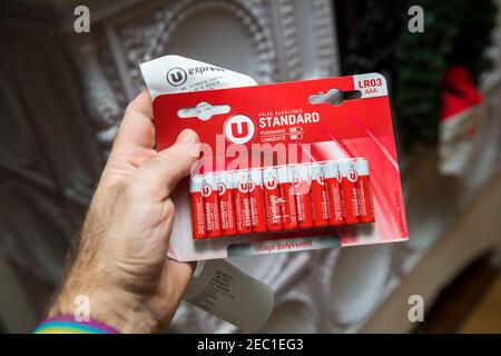 Parigi, Francia - 23 gennaio 2021: POV maschio mano reggendo nuovo pacchetto di batterie LR03 AAA prodotto per supermercati Regno Unito in Francia con la sua carta slip - pile di alcaline Foto Stock