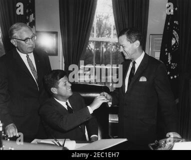 1991 Legge pubblica 415, Manpower Development u0026 Legge sulla formazione, 10:31. Il presidente John F. Kennedy (seduto alla scrivania) consegna una penna al senatore Joseph S. Clark (Pennsylvania) dopo aver firmato il Manpower Development and Training Act (legge pubblica 415). Il Congressman Elmer J. Holland (Pennsylvania) si trova sulla sinistra. Ufficio ovale, Casa Bianca, Washington, D.C. Foto Stock