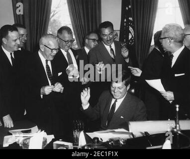 1991 Legge pubblica 415, Manpower Development u0026 Legge sulla formazione, 10:31. Il presidente John F. Kennedy (seduto alla scrivania) ride mentre consegna le penne dopo aver firmato il Manpower Development and Training Act (legge pubblica 415). Guardando sopra (L-R): Membro del Congresso Charles E. Goodell (New York); membro del Congresso Peter A. Garland (Maine); membro del Congresso Carroll D. Kearns (Pennsylvania); Direttore del Dipartimento di legislazione per la Federazione americana del lavoro e del Congresso delle organizzazioni industriali (AFL-CIO), Andrew J. Biemiller; membro del Congresso James G. Ou0027Hara (Michigan); membro del Congresso Adam Claysman Foto Stock