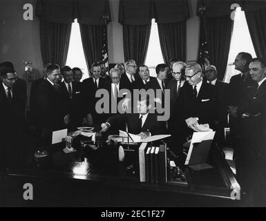 1991 Legge pubblica 415, Manpower Development u0026 Legge sulla formazione, 10:31. Il presidente John F. Kennedy (seduto alla scrivania) firma il Manpower Development and Training Act (legge pubblica 415). Guardando sopra (L-R): Senatore Winston L. Proputy (Vermont); congressman Neal Smith (Iowa); senatore Maurice J. Murphy, Jr. (New Hampshire); congressman Charles S. Joelson (New Jersey); congressman Charles E. Goodell (New York); congressman Peter A. Garland del Maine (parzialmente nascosto); Congressman Carroll D. Direttore del Dipartimento di legislazione per la Federazione americana di la Foto Stock