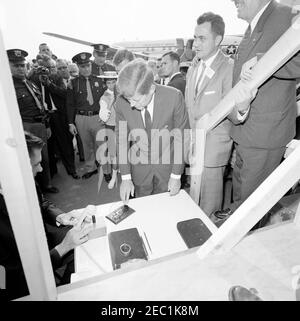 Viaggio della campagna del Congresso: Muskegon, Michigan, discorso all'aeroporto, cerimonia di apertura di un incontro massonico a Chicago. Il presidente John F. Kennedy si prepara a premere un pulsante per inaugurare un incontro massonico a Chicago, Illinois, durante un viaggio di campagna al Congresso all'aeroporto della contea di Muskegon, Michigan. Anche nella foto: Candidato al Congresso del Michigan, Neil Staebler (a destra, parzialmente fuori dal quadro); fotografo di newsreel per United Press Movietone, Thomas J. Craven, Sr.; funzionario della White House Communications Agency (WHCA), Joe Taylor; agenti della White House Secret Service, Walt Co Foto Stock