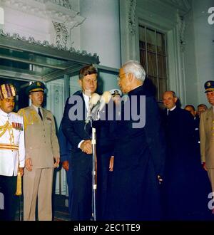 Cerimonia di arrivo del Dr. Sarvepalli Radhakrishnan, Presidente dell'India, 11:40. Il presidente John F. Kennedy stringe le mani con il presidente del Dr. Sarvepalli Radhakrishnan dell'India alle cerimonie di arrivo in onore del presidente Radhakrishnan. Da sinistra a destra: Aiuto militare indiano non identificato; Aide militare al presidente Kennedy, al generale Chester V. Clifton; al presidente Kennedy; Aide navale al presidente Kennedy, al capitano Tazewell Shepard (dietro, per lo più nascosto); al presidente Radhakrishnan; al segretario di Stato, Dean Rusk; al generale Maxwell D. Taylor. Portico Nord, Casa Bianca, Washington, D.C. Foto Stock