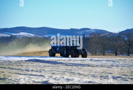 Trattore Valtra T194 e Agri-Spread AS65 che sparge calce su terreni innevati, Meikleour Estate, Blairgowrie, Perthshire, Scozia Foto Stock