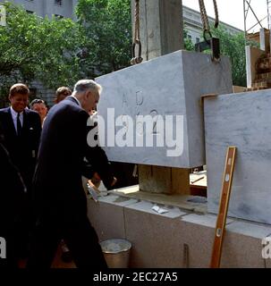 Cerimonia di posa Cornerstone, edificio degli uffici della Casa di Rayburn, 10:28. Il Presidente John F. Kennedy guarda il Presidente della Camera dei rappresentanti e il Presidente della Commissione per la costruzione degli uffici della Camera, John W. McCormack (Massachusetts), partecipare alla cerimonia di posa della pietra angolare per il Rayburn House Office Building, dedicato al defunto Presidente della Camera, Sam Rayburn. Washington, D.C. Foto Stock