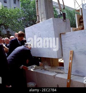 Cerimonia di posa Cornerstone, edificio degli uffici della Casa di Rayburn, 10:28. Il Presidente John F. Kennedy guarda il Presidente della Camera dei rappresentanti e il Presidente della Commissione per la costruzione degli uffici della Camera, John W. McCormack (Massachusetts), partecipare alla cerimonia di posa della pietra angolare per il Rayburn House Office Building, dedicato al defunto Presidente della Camera, Sam Rayburn. Rappresentante Charles MCC. Mathias, Jr., del Maryland guarda sopra (parzialmente nascosto dietro il presidente Kennedy). Washington, D.C. Foto Stock