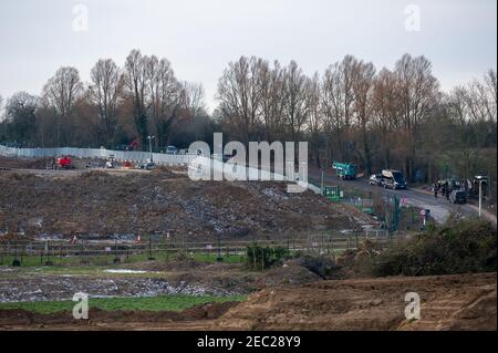 Harefield, Uxbridge, Middlesex, Regno Unito. 13 febbraio 2021. Bailiffs al campo questa mattina. I Bailiffs, agente di applicazione della squadra nazionale di viction, hanno sfromentato di fermare gli attivisti HS2 dal loro campo di Harvil Road nelle prime ore di questa mattina. Due manifestanti rimangono negli alberi del sito. HS2 hanno chiuso Harvil Road off da oggi fino al 21 febbraio. Numerosi addetti alla sicurezza HS2 hanno bloccato l'accesso alla strada questa mattina. HS2 Ltd stanno costruendo un viadotto attraverso Harvil Road per il controverso collegamento High Speed Rail 2 da Londra a Birmingham e hanno distrutto acri di alberi e campagna in Th Foto Stock
