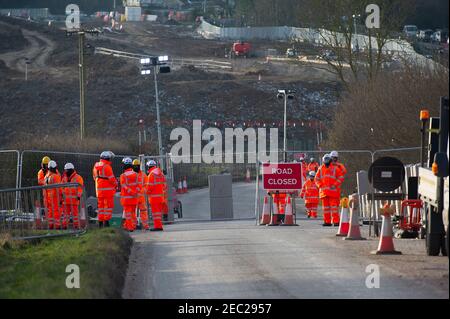 Harefield, Uxbridge, Middlesex, Regno Unito. 13 febbraio 2021. I Bailiffs, agente di applicazione della squadra nazionale di viction, hanno sfromentato di fermare gli attivisti HS2 dal loro campo di Harvil Road nelle prime ore di questa mattina. Due manifestanti rimangono negli alberi del sito. HS2 hanno chiuso Harvil Road off da oggi fino al 21 febbraio. Numerosi addetti alla sicurezza HS2 hanno bloccato l'accesso alla strada questa mattina. HS2 Ltd stanno costruendo un viadotto attraverso Harvil Road per il controverso collegamento High Speed Rail 2 da Londra a Birmingham e hanno distrutto acri di alberi e campagna nella zona. Credito: Maureen McLean/Alam Foto Stock
