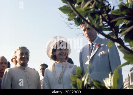 Prima Lady Jacqueline Kennedyu2019s (JBK) viaggio in India e Pakistan: Nuova Delhi, Delhi, India, visita al Mahatma Gandhi Memorial (Raj Ghat). First Lady Jacqueline Kennedy visita il Samadhi di Mohandas Gandhi, u201cRaj Ghat, u201d a Delhi, India. Il capo indiano del protocollo, S. K. Banerji (a sinistra), e l'ambasciatore degli Stati Uniti in India, John Kenneth Galbraith (a destra), stanno su entrambi i lati della sig.ra Kennedy. Altri non sono identificati. Foto Stock