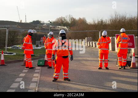 Harefield, Uxbridge, Middlesex, Regno Unito. 13 febbraio 2021. I Bailiffs, agente di applicazione della squadra nazionale di viction, hanno sfromentato di fermare gli attivisti HS2 dal loro campo di Harvil Road nelle prime ore di questa mattina. Due manifestanti rimangono negli alberi del sito. HS2 hanno chiuso Harvil Road off da oggi fino al 21 febbraio. Numerosi addetti alla sicurezza HS2 hanno bloccato l'accesso alla strada questa mattina. HS2 Ltd stanno costruendo un viadotto attraverso Harvil Road per il controverso collegamento High Speed Rail 2 da Londra a Birmingham e hanno distrutto acri di alberi e campagna nella zona. Credito: Maureen McLean/Alam Foto Stock