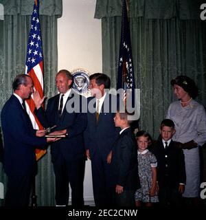 Giuramento in cerimonia, William Battle, Ambasciatore degli Stati Uniti in Australia, 17:14. Il presidente John F. Kennedy guarda sopra come capo del protocollo, Angier Biddle Duke, amministra il giuramento al neo-nominato ambasciatore degli Stati Uniti in Australia, William C. Battle, durante la cerimonia di giuramento del sig. Battleu0027s. Da sinistra a destra: Duke; Battaglia dell'Ambasciatore; Presidente Kennedy; Battaglia di W. Cullen, Jr.; Battaglia di Janie; Battaglia di Robert W.; Battaglia di Barry Webb. Sala armadio, Casa Bianca, Washington, D.C. Foto Stock