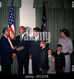 Giuramento in cerimonia, William Battle, Ambasciatore degli Stati Uniti in Australia, 17:14. Il presidente John F. Kennedy guarda sopra come capo del protocollo, Angier Biddle Duke, amministra il giuramento al neo-nominato ambasciatore degli Stati Uniti in Australia, William C. Battle, durante la cerimonia di giuramento del sig. Battleu0027s. Da sinistra a destra: Duke; Battaglia dell'Ambasciatore; Presidente Kennedy; Battaglia di W. Cullen, Jr.; Battaglia di Janie; Battaglia di Robert W.; Battaglia di Barry Webb. Sala armadio, Casa Bianca, Washington, D.C. Foto Stock