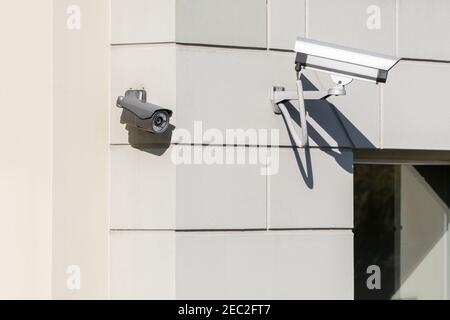 Moderne telecamere TVCC installate sulla parete dell'edificio in città. Concetto di sorveglianza e monitoraggio. Foto Stock