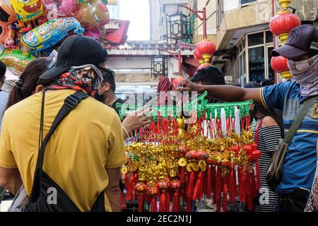 Ongpin St., Binondo, Manila, Filippine. 13 Feb 2021. Persone che cercano il fascino fortunato da acquistare a Ongpin St., Binondo, durante il Capodanno cinese. Binondo è conosciuta come la più antica chinatown del mondo, la maggior parte delle celebrazioni come le danze di drago e leoni sono state annullate a causa della pandemia. Credit: Notizie dal vivo di Mmaggioranza del mondo CIC/Alamy Foto Stock