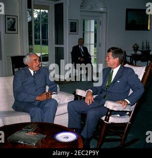 Incontro con Sir Alexander Bustamante, Premier della Giamaica, ore 10:04. Il presidente John F. Kennedy (in presidenza a dondolo) incontra il primo ministro della Giamaica, Sir Alexander Bustamante. Seduto in background è vice capo del protocollo, William J. Tonesk. Ufficio ovale, Casa Bianca, Washington, D.C. Foto Stock