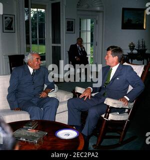 Incontro con Sir Alexander Bustamante, Premier della Giamaica, ore 10:04. Il presidente John F. Kennedy (in presidenza a dondolo) incontra il primo ministro della Giamaica, Sir Alexander Bustamante. Seduto in background è vice capo del protocollo, William J. Tonesk. Ufficio ovale, Casa Bianca, Washington, D.C. Foto Stock