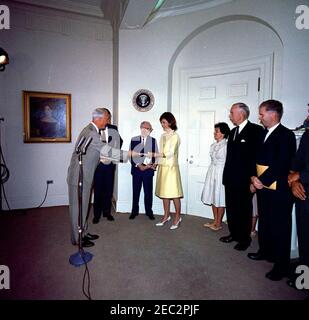 Presentazione della prima Guida della Casa Bianca al Presidente Kennedy u0026 First Lady Jacqueline Kennedy (JBK), 16:25. Presentazione della nuova guida della Casa Bianca al presidente John F. Kennedy e alla First Lady Jacqueline Kennedy da parte dei membri della National Geographic Society (NGS) e della White House Historical Association (WHHA); u0022La Casa Bianca: Una guida storica, u0022 una pubblicazione congiunta del NGS e del WHHHA, è stata stampata da Judd u0026 Detweiler, Inc. Presidente e redattore del NGS, Dr. Melville Bell Grosvenor (ai microfoni), presenta copie del libro alla Sig.ra Kennedy. A sinistra in Foto Stock