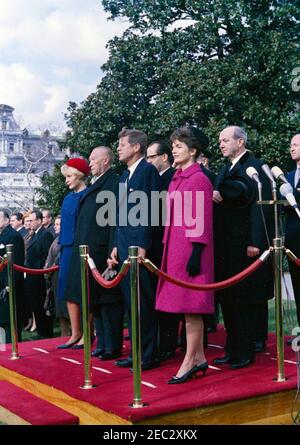 Cerimonie di arrivo per Konrad Adenauer, Cancelliere della Germania Occidentale, 10:45. Cerimonie di arrivo in onore del Cancelliere della Germania occidentale, Dr. Konrad Adenauer. In piedi sulla piattaforma di revisione: Il presidente John F. Kennedy; il cancelliere Adenauer; la prima signora Jacqueline Kennedy; Libeth Werhahn, figlia del cancelliere Adenauer; l'interprete per il ministero degli Esteri tedesco, Heinz Weber; il segretario di Stato degli Stati Uniti, Dean Rusk; il capo del protocollo degli Stati Uniti, Angier Biddle Duke. South Lawn, Casa Bianca, Washington, D.C. Foto Stock