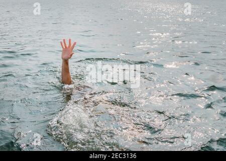 Una sola mano di annegare l'uomo in acqua chiedendo aiuto Foto Stock