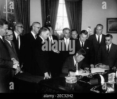 205 Legge pubblica 87-447, Legge sulla Televisione educativa, 12:00 PM. Il presidente John F. Kennedy (seduto) firma la legge sulla televisione educativa. In piedi (L-R): Senatore Clifford P. Case (New Jersey); congressista John E. Moss (California); non identificato; senatore Norris Cotton del New Hampshire (volto oscurato); congressista Oren Harris (Arkansas); congressista Hale Boggs (Louisiana); Segretario di Salute, Educazione e benessere, Abraham Ribicoff; avvocato G. Leonard, (Warren); magnate, Washington (Marks H. Springer (Illinois); il senatore John O. Pastore (Rhode Island Foto Stock