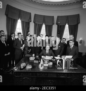 205 Legge pubblica 87-447, Legge sulla Televisione educativa, 12:00 PM. Il presidente John F. Kennedy (seduto) rilascia osservazioni dopo aver firmato la legge sulla televisione educativa. In piedi (L-R): Tre uomini non identificati; senatore Clifford P. Case (New Jersey); presidente della Federal Communications Commission (FCC), Newton Minow; congressista John E. Moss (California); non identificato; congressista Oren Harris (Arkansas); senatore Norris Cotton del New Hampshire (dietro); congressista Hale Boggs (Louisiana); Segretario per l'Educazione, e la Salute di Abraham, e la Salute di Abraham Ribadhamo; Senator Warren G. Magnuson (Washingt Foto Stock