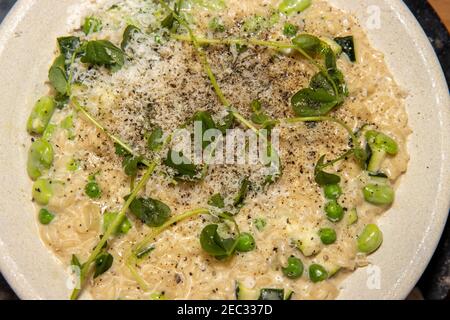 Vista dall'alto di un delizioso pasto di zucchine, fagiolo e risotto di piselli, su un tavolo da cucina in legno Foto Stock