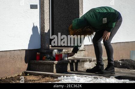 Radevormwald, Germania. 13 Feb 2021. Una donna mette una candela di fronte alla casa su Elberfelderstraße. Dopo un incendio di ieri sera, il dipartimento dei vigili del fuoco ha scoperto cinque corpi nella casa. La polizia non esclude la possibilità di un crimine di capitale. Credit: Jonas Güttler/dpa/Alamy Live News Foto Stock