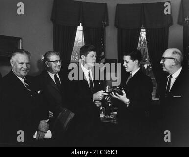 Visita del Boysu0027 Clubsu0027 u0022Boy dell'anno, u0022 Stephen Lutz, 10:57. Il presidente John F. Kennedy (al centro) possiede un modello in scala, racchiuso all'interno di una bottiglia, di PT Boat 109, presentato a lui dai Boysu0027 Clubs of Americau0027s (BCA) u0022Boy dello Yearu0022 Stephen Lutz di Newark, New Jersey. (L-R) Albert L. Cole, presidente della BCA; John M. Gleason, direttore nazionale della BCA; il presidente Kennedy; Stephen Lutz; e Charles R. Messier, direttore esecutivo dei Boysu0027 Clubs di Newark, New Jersey. Ufficio ovale, Casa Bianca, Washington, D.C. Foto Stock