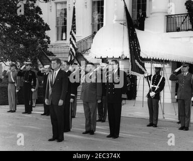 Il presidente Kennedy saluta i destinatari della Medaglia d'onore del Congresso, ricevimento militare annuale, alle 18:03. Il presidente John F. Kennedy (a sinistra, in primo piano) partecipa a un ricevimento militare in onore dei destinatari della medaglia d'onore del Congresso. Stando direttamente dietro il presidente Kennedy: Militare Aide al presidente, generale Chester V. Clifton; Air Force Aide al presidente, brigadiere generale Godfrey T. McHugh; Naval Aide al presidente, capitano Tazewell Shepard. Portico Sud, Casa Bianca, Washington, D.C. Foto Stock