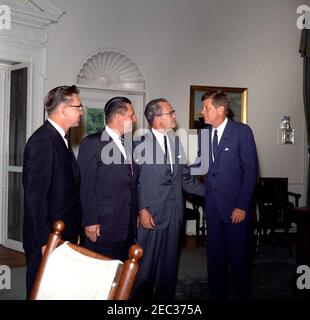 Incontro con il governatore Grant Sawyer del Nevada e i senatori Alan Bible e Howard W. Cannon (Nevada), 16:35. Il presidente John F. Kennedy si trova in piedi con funzionari del Nevada. Da sinistra a destra: Il governatore Grant Sawyer, il senatore Howard W. Cannon, la Bibbia del senatore Alan e il presidente Kennedy. Ufficio ovale, Casa Bianca, Washington, D.C. Foto Stock