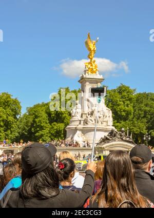 LONDRA, INGHILTERRA - LUGLIO 2018: Persona che usa un bastone di selfie per scattare una foto di una band di marcia fuori Buckingham Palace Foto Stock