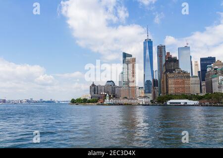 Vista del paesaggio urbano del quartiere finanziario di Manhattan dal barca sul mare con cielo blu nuvoloso Foto Stock