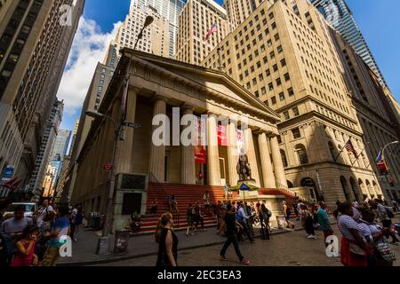 Vista della Federal Hall al 26 di Wall Street in Il quartiere finanziario con i turisti a piedi sulla strada Foto Stock