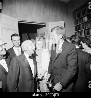 Viaggio a New York: Ricevimento, residenza Arthur Krim. Il presidente John F. Kennedy visita con l'intrattenitore Jimmy durante (a sinistra, in primo piano) e Margie durante (al centro) durante un ricevimento serale presso la residenza di Arthur B. Krim e Dr. Mathilde Krim a New York City, New York. Il compositore Richard Adler si trova a sinistra. Foto Stock