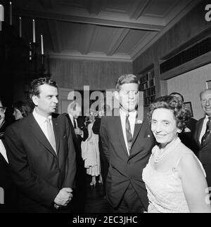 Viaggio a New York: Ricevimento, residenza Arthur Krim. Il presidente John F. Kennedy visita con il compositore Richard Adler (a sinistra), E co-presidente del saluto di compleanno del presidente Kennedyu2019s (tenuto al Madison Square Garden prima di sera), Anna M. Rosenberg (a destra), durante un ricevimento serale presso la residenza di Arthur B. Krim e Dr. Mathilde Krim a New York City, New York. Jean Kennedy Smith si trova all'estrema sinistra (sullo sfondo); il senatore Jacob K. Javits (New York) si trova sul bordo destro dell'immagine. Foto Stock