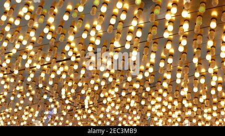 Le vecchie lampade elettriche che funzionano lampeggiano e si illuminano di notte. Primo piano astratto della decorazione del casinò retrò scintillante a Las Vegas, Stati Uniti. Luce di colore Foto Stock