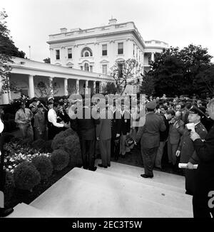 Visita dei cadetti stranieri di pattuglia aerea civile, 9:35. Il presidente John F. Kennedy (centro, ritorno alla telecamera) visita con cadetti stranieri di pattuglia aerea civile. Il senatore Hubert Humphrey (Minnesota) è a sinistra del presidente; tutti gli altri sono non identificati. Rose Garden, Casa Bianca, Washington, D.C. Foto Stock