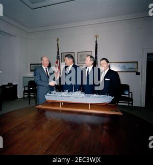 Presentazione di un modello di barca PT per il presidente Kennedy. Assistente speciale al Presidente Dave Powers visite con tre rappresentanti non identificati del Washington International Boat and Sport Show nella Fish Room della Casa Bianca, Washington, D.C. seduto sul tavolo è un modello di PT Boat 109 che hanno presentato al Presidente John F. Kennedy. [Vedi anche MO 63.1212, u201cModello di PT 109.u201d] Foto Stock