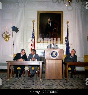 Cerimonia di firma, piani per il progresso - il Comitato per le pari opportunità di lavoro del Presidente 0027s, 16:40. Hobart Taylor, Jr., Vice Presidente Esecutivo del Comitato per le pari opportunità di lavoro (PCEEO) del Presidente 0027s, interviene in una cerimonia di firma dei piani di progresso; funzionari di venti società hanno firmato accordi di lavoro per pari opportunità come parte del programma. Da sinistra a destra: Segretario del lavoro, W. Willard Wirtz; Presidente John F. Kennedy; Sig. Hobart; Vice Presidente Lyndon B. Johnson. State Dining Room, White House, Washington, D.C. Foto Stock