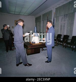 Il presidente Kennedy con una capsula Gemini modello. Il presidente John F. Kennedy vede un modello in scala di una capsula Gemini nella stanza del gabinetto della Casa Bianca, Washington, D.C.; Il modello è stato dato al presidente Kennedy come regalo di Natale dal personale della McDonnell Aircraft Corporation, dopo la visita del presidente 2019 allo stabilimento di McDonnellu2019s St. Louis il 12 settembre 1962. Air Force Aide al presidente, Brigadier General Godfrey T. McHugh, si trova a destra; White House Photographer, Captain Cecil Stoughton, si trova a sinistra. [Vedi anche MO 63.1922a-c, u0022modello in scala della Gemini Spacecra Foto Stock