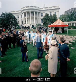 First Lady Jacqueline Kennedyu0027s (JBK) programma musicale per giovani, 14:10. Il presidente John F. Kennedy (centro) saluta i membri del Berea (Kentucky) College Country Dancer sul prato sud della Casa Bianca, Washington, D.C.; i fotografi e altri osservano. Il gruppo di danza ha suonato come parte della sesta puntata di First Lady Jacqueline Kennedyu2019s Musical Programs for Youth by Youth. Foto Stock