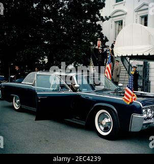 Cerimonia di arrivo per Jorge Alessandri Rodru00edguez, Presidente del Cile, 11:15. Cerimonia di arrivo per il Presidente del Cile, Jorge Alessandri Rodru00edguez. Il presidente John F. Kennedy e il presidente Alessandri Rodru00edguez (entrambi per lo più nascosti) si siedono sul sedile posteriore della limousine presidenziale (Lincoln-Mercury Continental convertibile con tettuccio a bolla), prima di partire per Blair House. Naval Aide al presidente Kennedy, il capitano Tazewell T. Shepard, Jr., siede sul sedile anteriore dell'automobile. South Lawn vialetto, Casa Bianca, Washington, D.C. Foto Stock