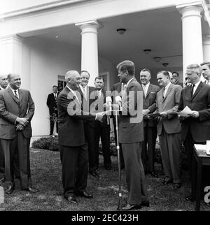 Presentazione del Presidentu2019s Distinguished Civilian Service Awards, ore 12:00. Cerimonia di presentazione del Premio Presidentu2019s per il distinto Servizio civile federale. Il presidente John F. Kennedy scuote le mani con il presidente della Federal National Mortgage Association of the Housing and Home Finance Agency (HHFA), J. Stanley Baughman (centro a sinistra), presentandolo con il premio. Guardando sopra (L-R): Vincitore del premio e direttore del centro di Spacecraft presidiato, il Dott. Robert Gilruth (nel retro, parzialmente nascosto); amministratore del HHFA, Robert C. Weaver; White House Secret Service ag Foto Stock
