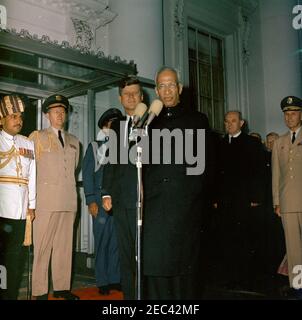 Cerimonia di arrivo del Dr. Sarvepalli Radhakrishnan, Presidente dell'India, 11:40. Il presidente del Dr. Sarvepalli Radhakrishnan dell'India parla alle cerimonie di arrivo in suo onore. Da sinistra a destra: Aiuto militare indiano non identificato; Aide militare al presidente Kennedy, al generale Chester V. Clifton; Aide dell'aeronautica al presidente Kennedy, al generale del brigadiere Godfrey T. McHugh (per lo più nascosto); al presidente John F. Kennedy; al presidente Radhakrishnan; al segretario di Stato, Dean Rusk; al generale Maxwell D. Taylor. Portico Nord, Casa Bianca, Washington, D.C. Foto Stock