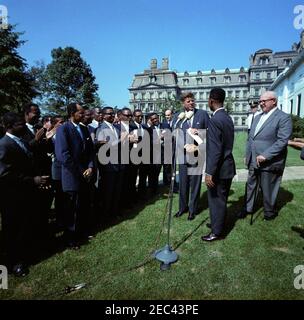 Visita dei partecipanti all'American Institute for Free Labor Management, ore 10:05. Visita dei partecipanti al programma di formazione dell'American Institute for Free Labour Development (AIFLD) per i leader sindacali dell'America Latina e dei Caraibi sul prato dell'ala occidentale della Casa Bianca, Washington, D.C. il presidente John F. Kennedy (centro destra) scuote le mani con il partecipante Eric Lloyd Harris, della Giamaica; Il presidente della Federazione americana del lavoro e del Congresso delle organizzazioni industriali (AFL-CIO), George Meany, si trova a destra. [Vedi anche Federazione americana del lavoro e Congresso dell'Organizzazione industriale Foto Stock