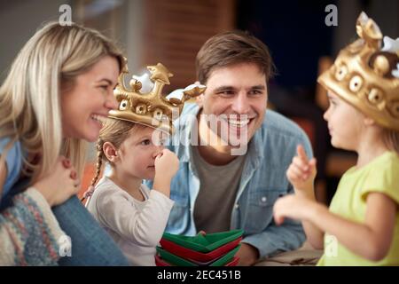 Genitori allegri che giocano insieme ai loro figli a casa; concetto di tempo di famiglia Foto Stock