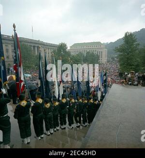 Viaggio a West Virginia: Indirizzo alla celebrazione del Centennial della West Virginia, state Capitol Building, Charleston, 11:30. Vista degli spettatori riuniti sotto la pioggia di fronte al Campidoglio di Stato a Charleston, West Virginia, per una celebrazione commemorativa del centenario della West Virginia, alla quale ha partecipato il presidente John F. Kennedy. Le guardie di colore Boy Scout tengono bandiere in primo piano. [Fotografia di Harold Sellers] Foto Stock