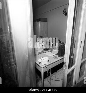 Prima Lady Jacqueline Kennedyu2019s (JBK) viaggio in India e Pakistan: White House Army Signal Agency / White House Communications Agency (WHASA / WHCA) preparazione del personale. Un uomo non identificato parla al telefono come White House Army Signal Agency / White House Communications Agency (WHASA / WHCA) personale di impostare le apparecchiature di comunicazione per il viaggio First Lady Jacqueline Kennedyu2019s in India e Pakistan. Foto Stock