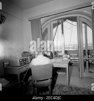 Prima Lady Jacqueline Kennedyu2019s (JBK) viaggio in India e Pakistan: White House Army Signal Agency / White House Communications Agency (WHASA / WHCA) preparazione del personale. Un uomo non identificato parla al telefono come White House Army Signal Agency / White House Communications Agency (WHASA / WHCA) personale di impostare le apparecchiature di comunicazione per il viaggio First Lady Jacqueline Kennedyu2019s in India e Pakistan. Foto Stock